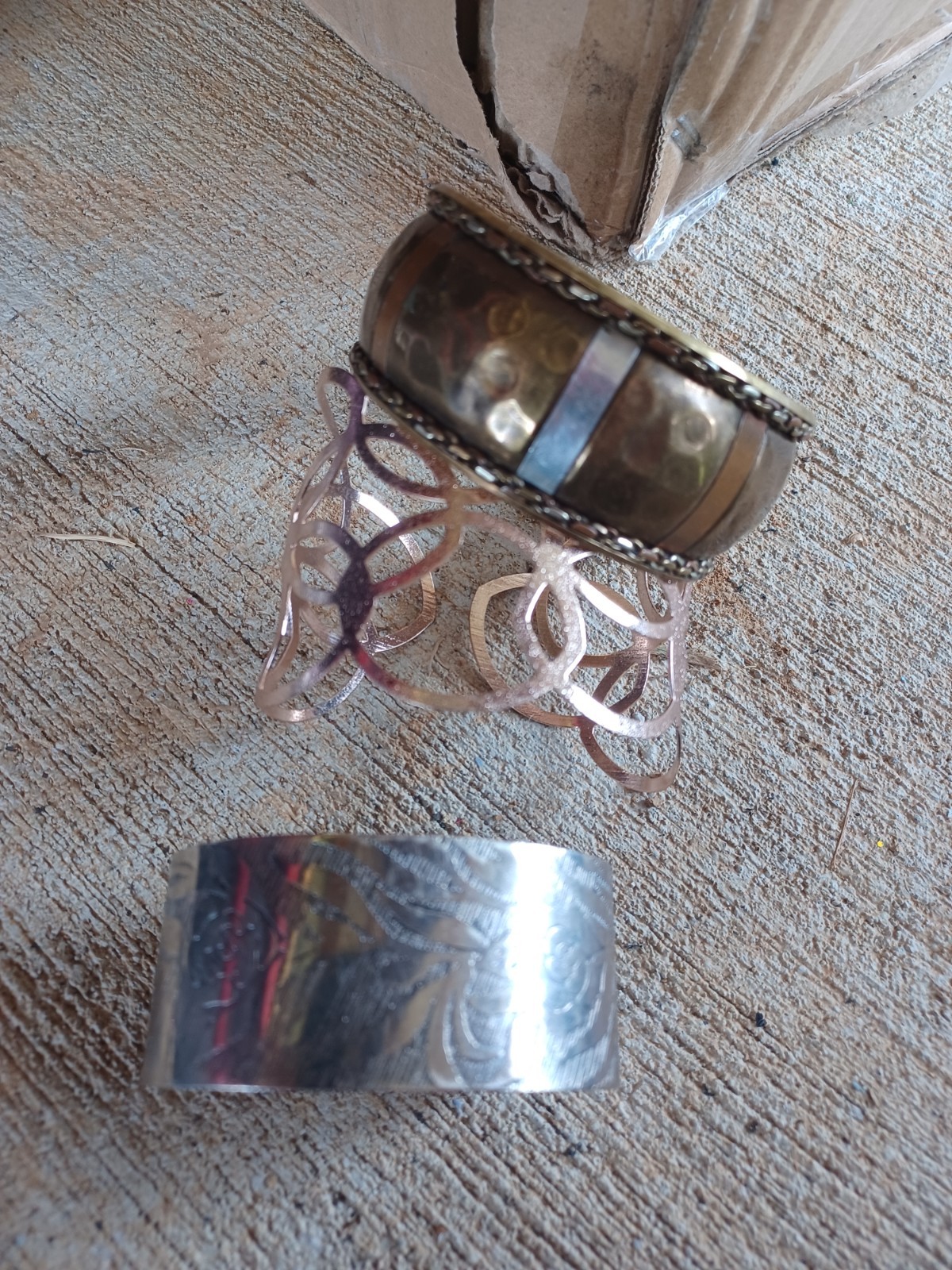 set of three mixed-metal cuff bracelets featuring various brass, copper, silver